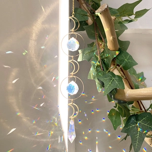 Golden moon suncatcher with crystal prisms reflecting rainbow light on a wall surface