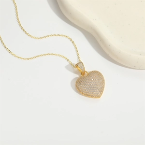 Elegant gold heart pendant necklace with shimmering white zircon inlay on white background