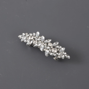 Macro shot of silver rhinestone hair clip with teardrop crystals on grey background