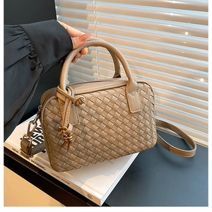 Detail of khaki woven Boston bag with gold hardware and removable shoulder strap
