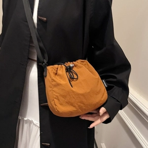 Caramel drawstring bucket bag in lightweight fabric with black strap for women