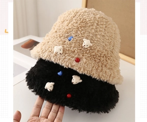 Close-up of plush bucket hat featuring cute bear patches and colorful button details