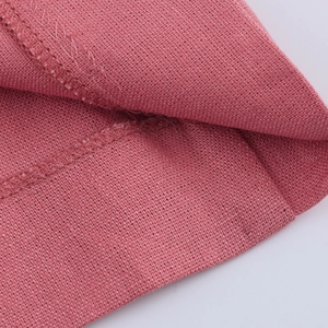 Detail shot of pink cotton-linen fabric showing texture and neat stitching seams