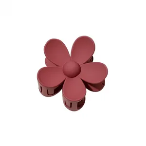 Detailed view of dusty pink matte flower claw clip with spring hinge on white background