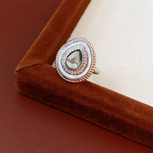 Gros plan d'une bague en argent en forme de goutte avec pierre bleue et nacre blanche