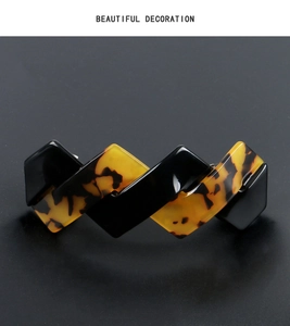 Elegant wavy acetate hair clip in tortoiseshell and black finish shown in detail