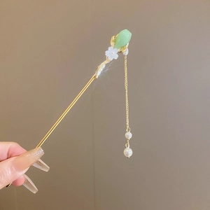 Détail de l'épingle à cheveux fleur dorée avec pierre de jade verte et pompons perlés