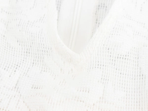 Detailaufnahme der weißen Spitze und des verdeckten Reißverschlusses am schmalen Kleid