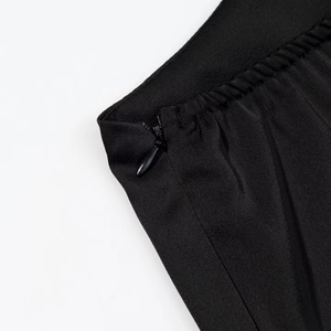 Gros plan détaillé d'une robe noire avec fermeture éclair invisible et taille élastique