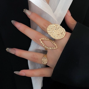 Macro shot of gold textured rings featuring hammered oval and hollow wavy designs on hand