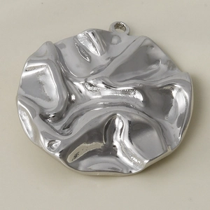 Détail macro du pendentif en acier inoxydable argenté avec texture plissée et finition brillante