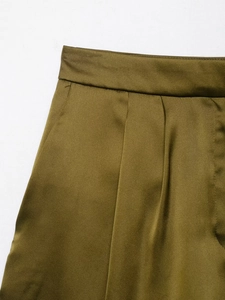 Detail der olivgrünen Satinhose mit plissiertem Bund und glatter Stoffstruktur