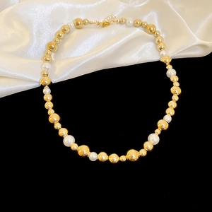 Detail view of heart-shaped faux pearl and gold metal bead choker with lobster clasp