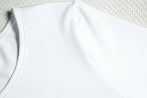 Détails de la robe blanche à épaules dénudées montrant la maille et les coutures de qualité