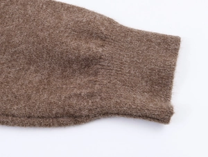 Gros plan sur un pull en maille peluche marron montrant les poignets côtelés et la texture