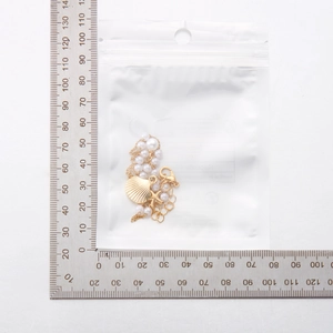 Vue détaillée du collier perles étoile de mer et coquillage avec échelle de mesure