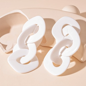 Détail macro de boucles d'oreilles en acrylique blanc avec gros maillons ovales