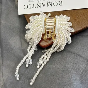 Elegant gold hair claw clip featuring pearls, crystal tassels, and romantic floral design