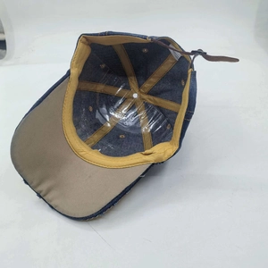 Internal view of navy denim baseball cap with yellow lining and leather strap