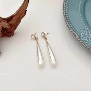 Macro detail of French vintage baroque pearl teardrop earrings with gold plating