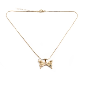 Macro detail of gold butterfly pendant with colorful zircon stones on thin chain