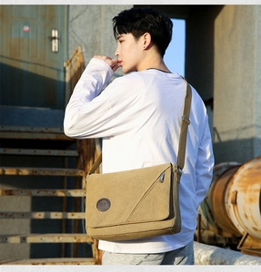 Khaki canvas messenger bag for men shown on a model in an urban outdoor setting