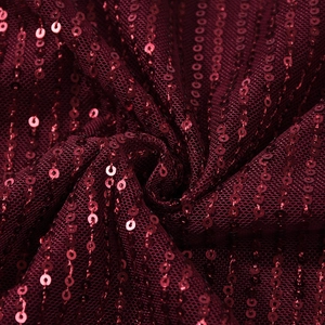 Makroaufnahme hochwertiger burgunderroter Pailletten auf zartem Netzgewebe für Kleider
