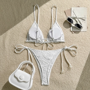 Flat lay of white halter bikini with textured fabric and side-tie details