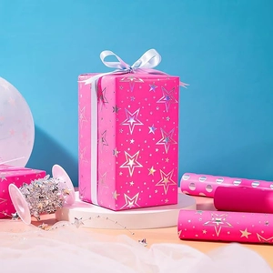 Vibrant Barbie pink wrapping paper with holographic gold stars and gift box on white stand