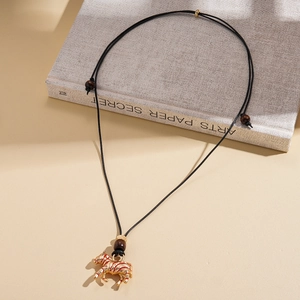 Detail of golden zebra pendant with red stripes on adjustable leather cord with wood beads