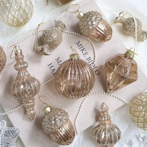 Champagne gold glitter glass Christmas ornaments in assorted geometric shapes and textures