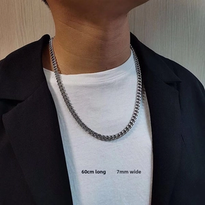 Detail showing 60cm length and 7mm width of the silver Cuban link chain on a male model