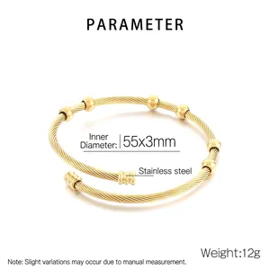 Detail view of a 12g golden stainless steel cable bangle with six beads and open design