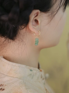 Detail view of gold hoop earrings with three natural green aventurine beads on model