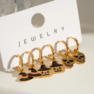 Detail view of 3 pairs of Halloween earrings with pumpkin, skull, and wizard hat charms