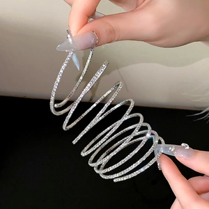 Macro-opname van de verzilverde spiraalarmband met fonkelende strass en elastisch ontwerp