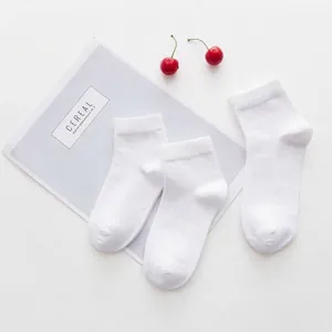 White cotton kids crew socks for students flat lay with cherry and magazine decor
