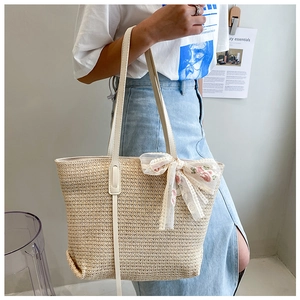 Detail of handwoven straw tote bag with delicate floral lace bow and textured fiber finish