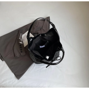 Interior view of black woven bucket bag showing large capacity lining and zipper pocket