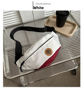 Close-up of a white and red contrast nylon sling bag with a leather logo on a glass cart