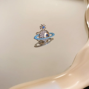Macro shot of silver planetary ring featuring blue enamel and sparkling cubic zirconia stones