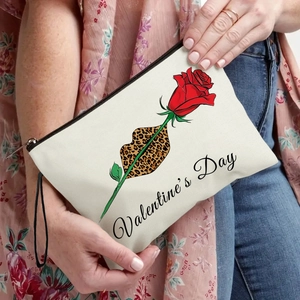Canvas makeup bag with rose and lip pattern shown in a lifestyle model hand setting