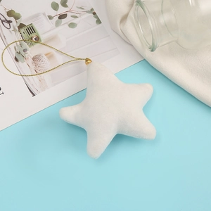 Close-up of white plush star charm with gold cord on a soft light blue background