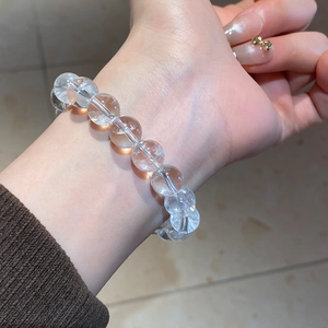 Detailed view of high-transparency white crystal beaded bracelet on a woman wrist