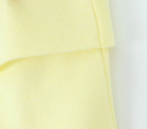 Primer plano de la textura del tejido de punto amarillo claro y costuras de doble aguja