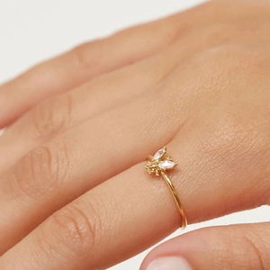 Close-up of golden bee ring with white zircon wings worn on a woman's finger