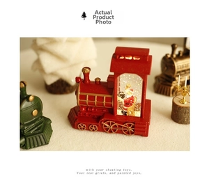 Close-up of decorative Christmas train snow globes with Santa Claus figures and lights