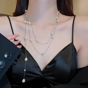 Close-up of triple-layered necklace featuring irregular baroque pearls on delicate chains