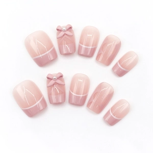 Unghie finte sfumate rosa con punte French e fiocco 3D decorato con perle chic