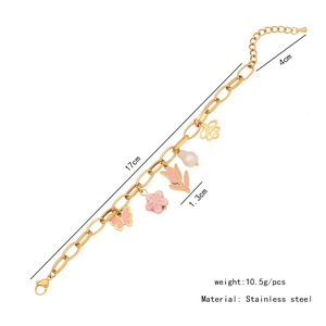 Detail view of pink bow and flower charms on a gold stainless steel bracelet with dimensions